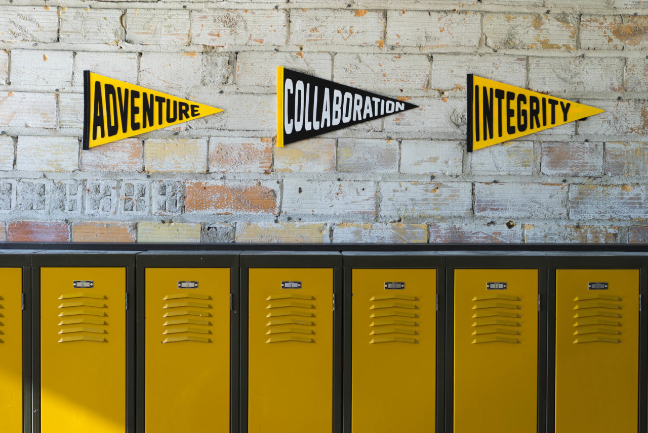 Pennants showing Lemonly's core values of Adventure, Collaboration, and Integrity hanging on the wall at Lemonly HQ